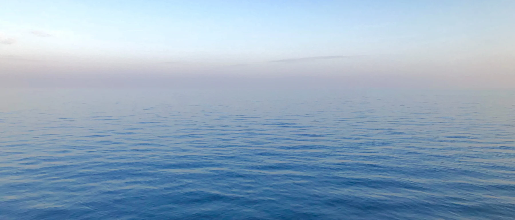 Mar en calma y cielo abierto, sin más referencia que la línea del horizonte.